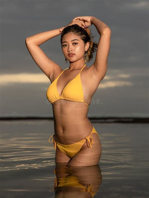 Sunset Time On The Beach Beautiful Asian Woman Posing In Yellow Bikini Tanned Skin Slim Fit