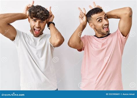 Jeune Couple Gay Debout Sur Fond Isol Posant Dr Le Et Fou Avec Des Doigts Sur La T Te Comme Des