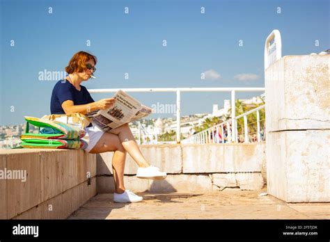Woman Smoking While Reading Newspaper High Resolution Stock Photography