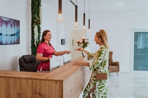 Premium Photo Beautiful Blonde Shakes Hands With An Employee Of The Dental Office After The