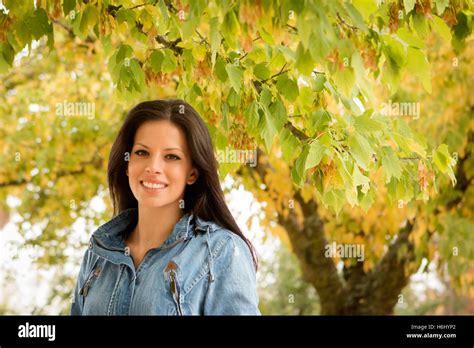 Beautiful Brunette Girl Taking A Walk By A Park In Autumn Stock Photo Alamy
