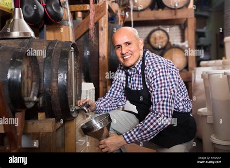 Gay Mature Man Seller Filling Wine From Wood In Wine House Stock Photo Alamy