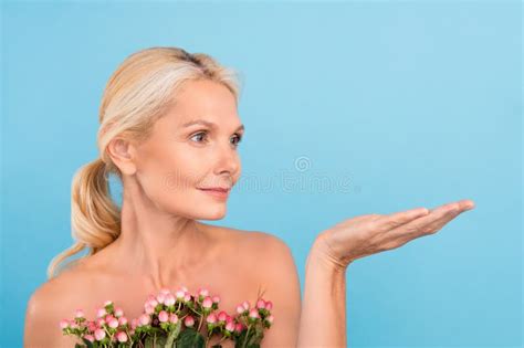 Photo Of Shiny Pretty Elderly Lady Naked Shoulders Holding Flowers Bunch Showing Arm Empty Space