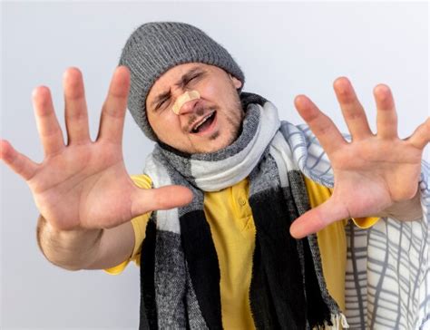 Insatisfait jeune homme slave malade blonde portant un chapeau d hiver et une écharpe Photo