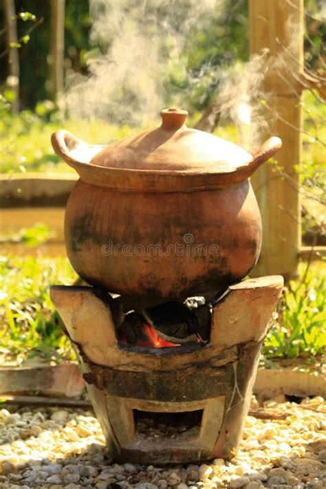 Cooking In The Clay Pot On Fire In The Countryside Of Thailand Stock