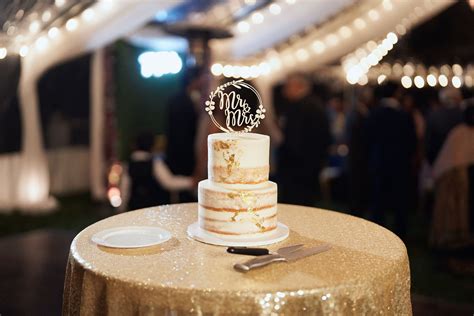 Two Tier Naked White Wedding Cake With Gold Flakes And Cake Topper