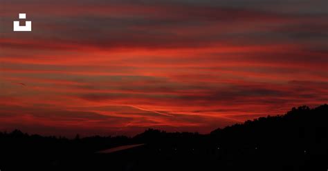 A red and black sky with clouds and trees photo – Free Colourful ...