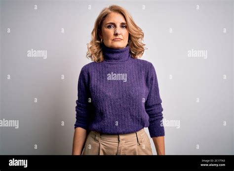 Middle Age Beautiful Blonde Woman Wearing Purple Turtleneck Sweater Over White Background With