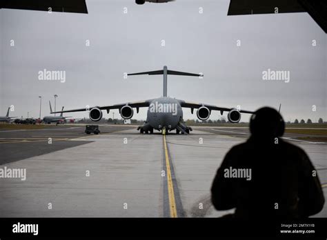 ein lockheed   hercules taxi auf der landebahn mit einer boeing