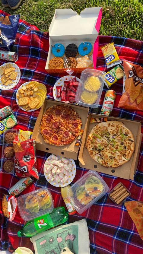 A Picnic Blanket With Pizzas Snacks And Other Food Items Laid Out On It