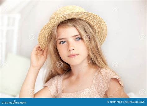 Portrait D une Jolie Fille Sous Un Chapeau De Paille Petite Blonde Réfléchie Aux Cheveux Longs