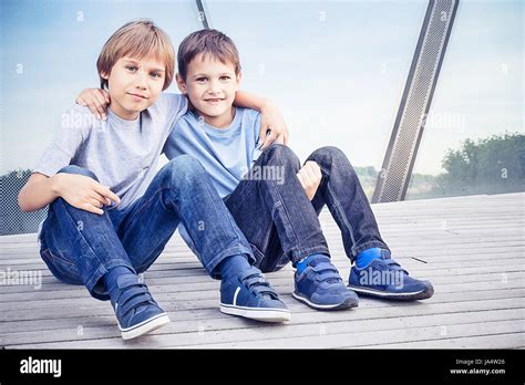 Two Happy Kids Sitting Together And Embracing Stock Photo Alamy