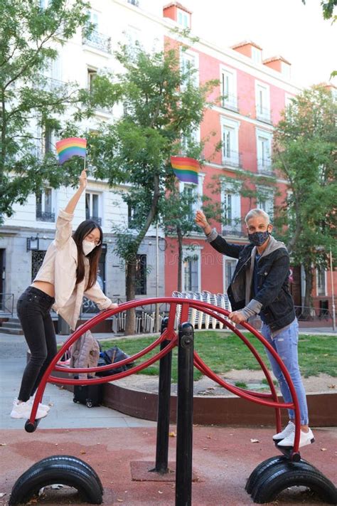 Joven Caucásico Gay Hombre Y Joven Lesbiana Asiática Jugando En Una Sierra Usando Máscaras Y Con