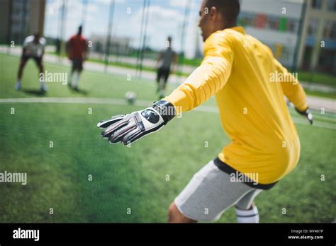 Side View Of African American Goalkeeper Standing On Soccer Pitch Stock