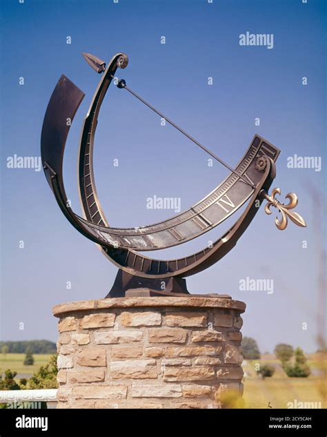 1960s SUNDIAL OUTDOOR ON STONE PEDESTAL ON BRIGHT SUNNY DAY CAST SHADOW OF ARROW POINTER ...