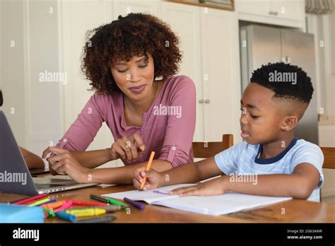 Happy African American Mother And Son Doing Homework At Home Smiling