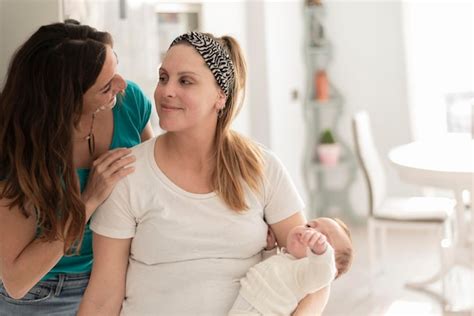 Premium Photo A Lesbian Couple Holding A Their Baby And Smiling To Each Other Gay Marriage Gay