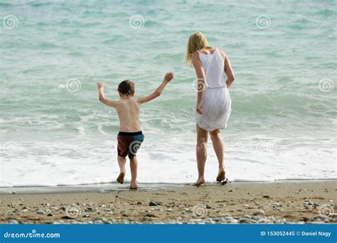Genieten De Blonde Slanke Moeder En Haar Kind Samen Van De Zomer