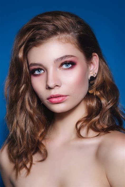 Beautiful Woman With Long Brunette Hair Salon Curly And Perfect Beauty Makeup On Blue Background