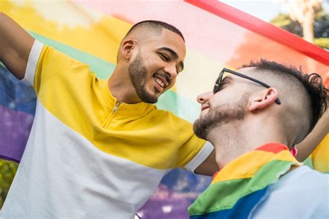 Pareja Gay Abrazando Y Mostrando Su Amor Con La Bandera Del Arco Iris Foto Premium