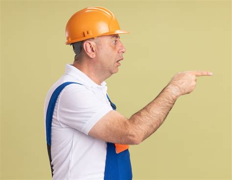 Free Photo Shocked Adult Builder Man In Uniform Stands Sideways