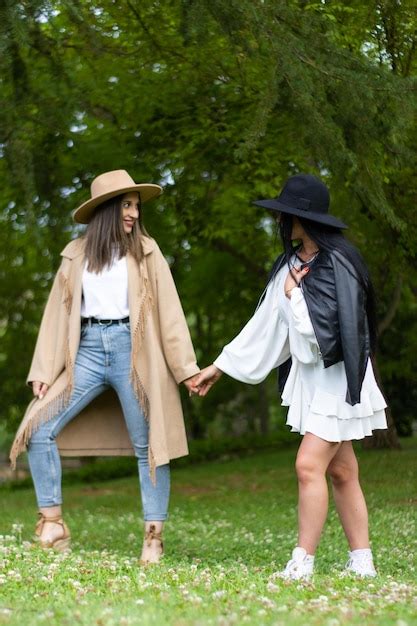 Premium Photo A Stylish Lesbian Couple Holding Hands And Walking In The Park