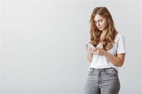 Sérieuse Jeune Fille Blonde à L aide De Téléphone Mobile Regardant L écran Du Smartphone