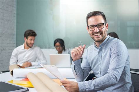 Portrait Of Smiling Young Businessman Holding Paper Document And