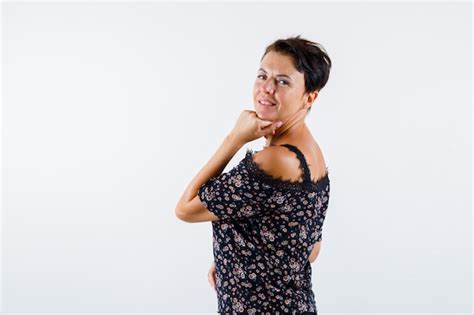 Femme Mature En Chemisier Floral Jupe Noire Tayant Le Menton Sur Place Regardant Par Dessus L