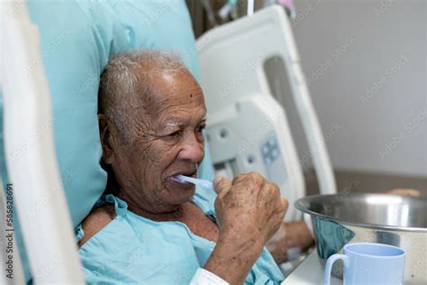 Foto Stock inpatient man brushing teeth for mouth hygiene on patient ...