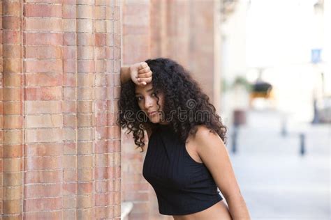 Bella Latina Con Ojos Negros Y Cabello Largo Y Oscuro Y Rizado Descansa Sobre Un Brazo Inclinado