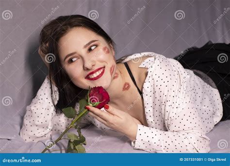 Brunette Woman With Kisses Lipstick Marks On Her Face And Neck With