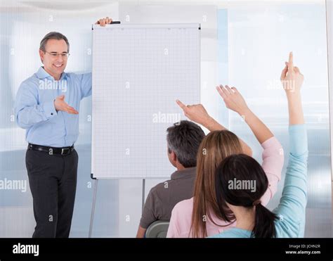 Happy Mature Male Teacher Teaching Student In Classroom Stock Photo Alamy