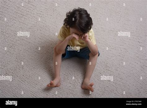 View Of Thoughtful Cute Little Boy Covering His Eyes With His Hand