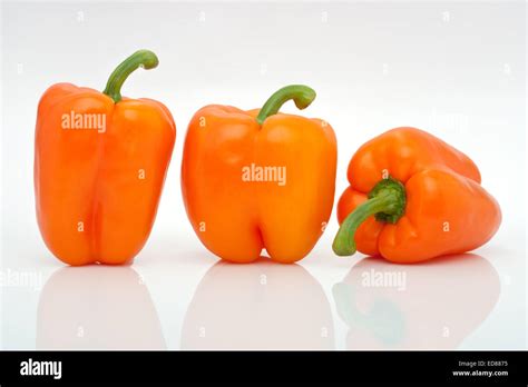 Tree Orange Peppers In A Row Isolated On White Background Stock Photo
