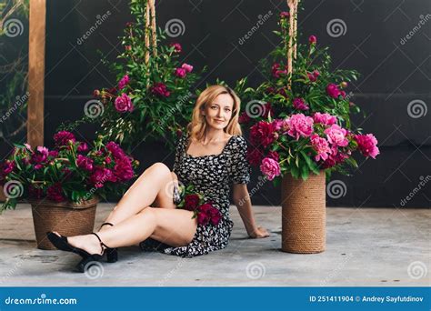 Eine H Bsche Blonde Frau Im Mittelalter Sitzt Mit Blumen Auf Dem Boden Stockfoto Bild Von