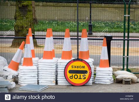 Stacked Traffic Cones And A Stop Work Sign On The Side Of A Fenced Off