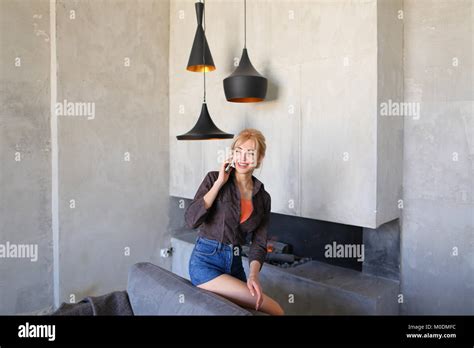 Female Blonde Speaks On Cellular And Walks Around Living Room S Stock Photo Alamy