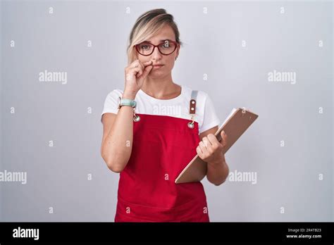 Jeune Femme Blonde Portant Un Uniforme De Serveur Tenant La Bouche Du Presse Papiers Et Les