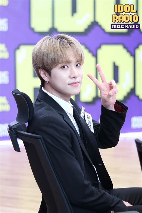 A Young Man Sitting In A Chair With His Hand Up To The Side While