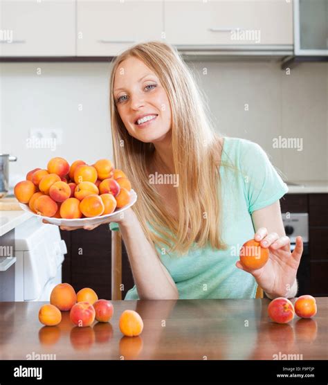Gl Ckliche Junge Blonde Hausfrau Mit Haufen Von Aprikosen T K Che Stockfotografie Alamy