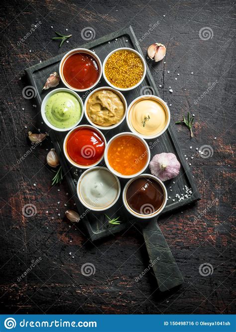 Different Types Of Sauces In Bowls On A Cutting Board With Garlic Stock