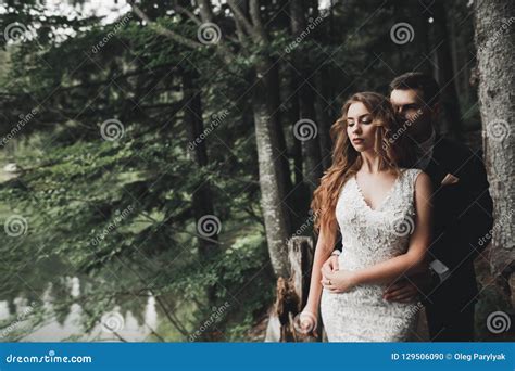 Elegant Stylish Happy Brunette Bride And Gorgeous Groom On The Background Of A Beautiful River