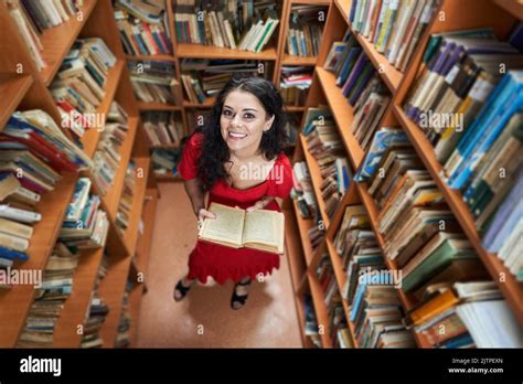 Attractive Brunette Librarian In Red Dress In A Library Full Of Books Stock Photo Alamy