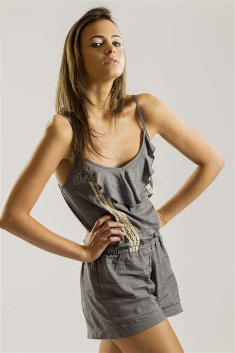 Lovely Long Haired Brunette Model Holding An Empty Pail While Posing In A Studio Environment