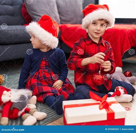 Adorable Boy and Girl Celebrating Christmas Holding Candies at Home