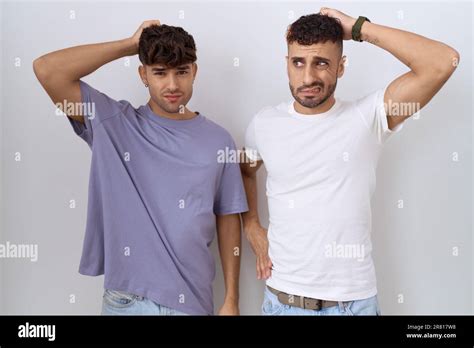 Homosexuel Gay Couple Debout Sur Fond Blanc Confusion Et Se Demandant Au Sujet De La Question