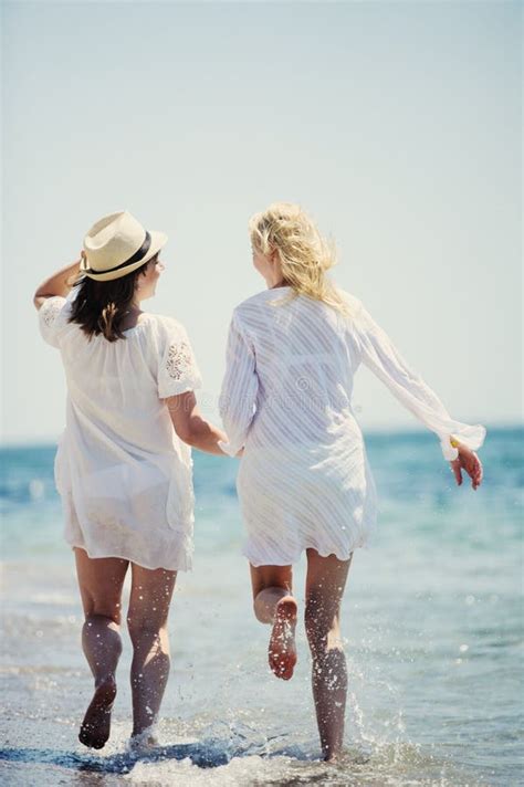 Les Filles Heureuses Qui Courent Sur La Plage De La Mer Image Stock