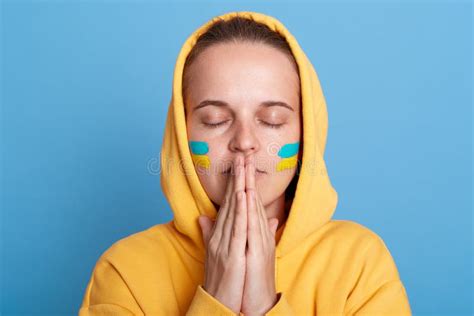 Portrait Of Sad Hopeful Woman Wearing Yellow Hoodie And With Flag Of