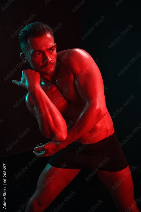 Man Bodybuilder Posing Muscles With Nude Fitness Torso Isolated On Black Background In Neon